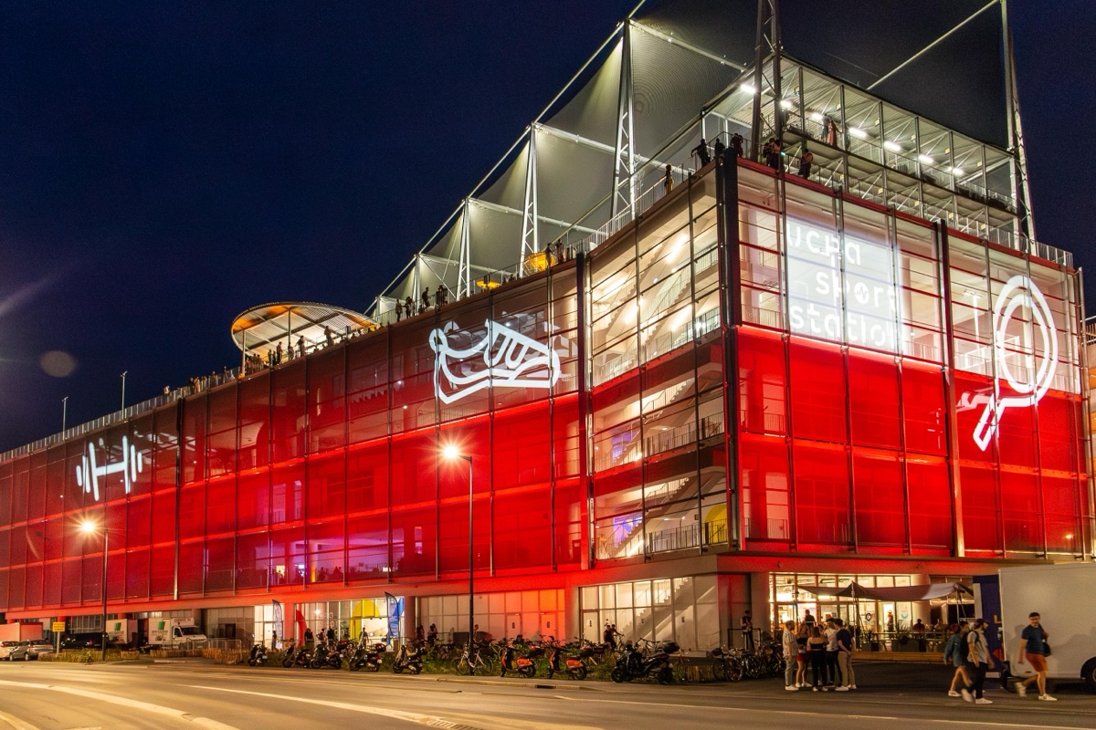 UCPA Sport Station Bordeaux illuminé de nuit, façade rouge